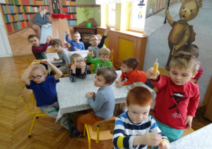 Dzieci przy stolikach ze swoimi świecami woskowymi